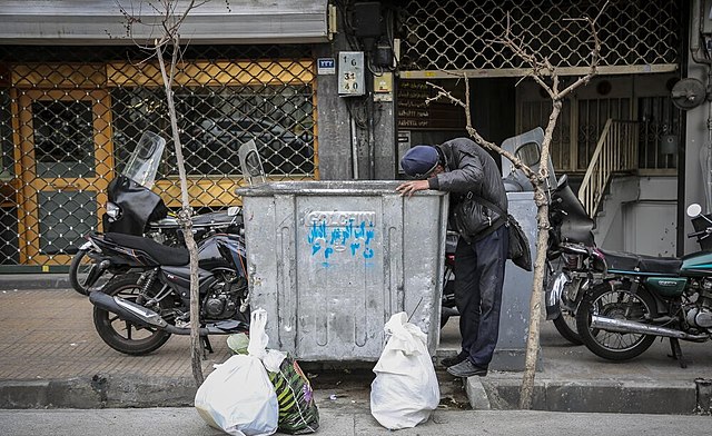 A waste picker looks for recyclates in a paladin container in Iran 